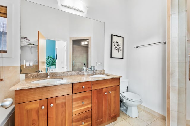 full bath with a stall shower, a sink, toilet, and tile patterned floors