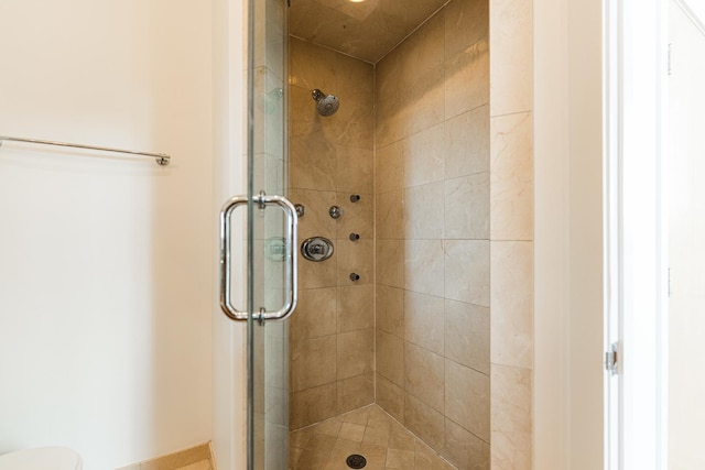 bathroom with a shower stall and toilet