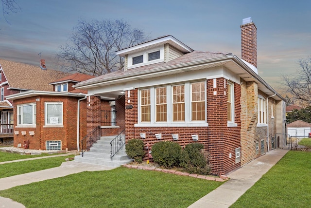 bungalow featuring a front yard, brick siding, fence, and a chimney