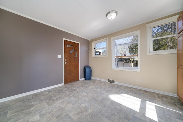 empty room featuring visible vents, baseboards, ornamental molding, and stone finish flooring