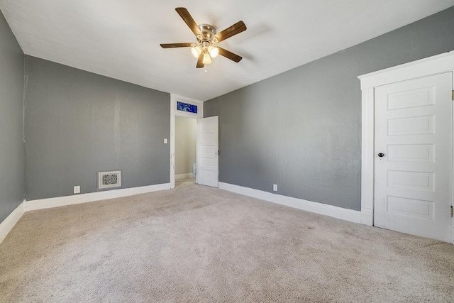 spare room featuring visible vents, carpet floors, baseboards, and a ceiling fan