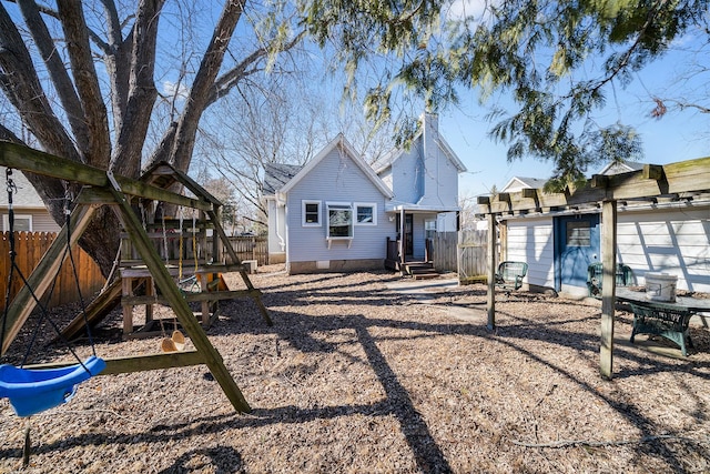 back of property featuring crawl space, a playground, and fence