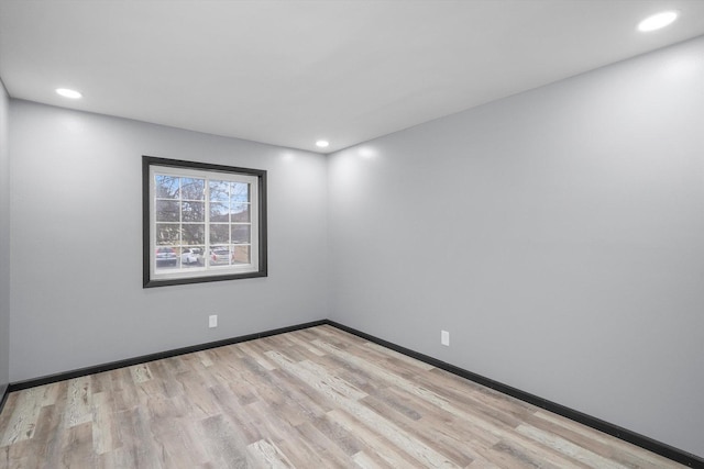 empty room featuring baseboards, light wood finished floors, and recessed lighting