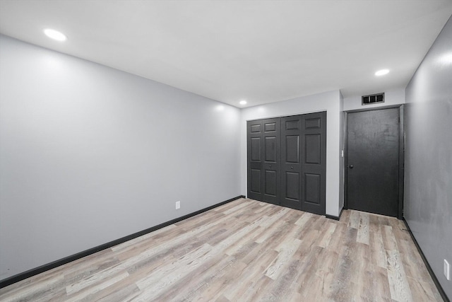 unfurnished bedroom with baseboards, visible vents, light wood-type flooring, a closet, and recessed lighting