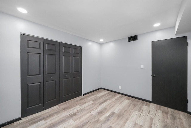 unfurnished bedroom featuring light wood finished floors, baseboards, visible vents, a closet, and recessed lighting