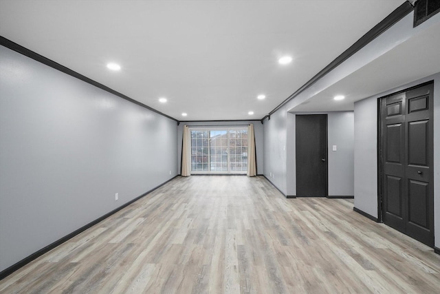 empty room featuring light wood-style floors, baseboards, ornamental molding, and recessed lighting