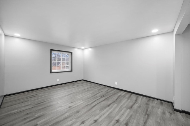 empty room featuring recessed lighting, wood finished floors, and baseboards