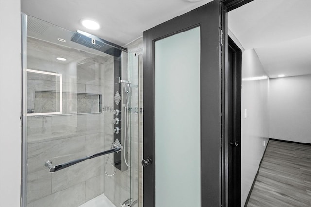 bathroom featuring wood finished floors, a shower stall, and recessed lighting