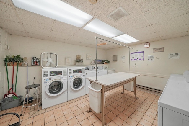 common laundry area featuring light tile patterned floors, visible vents, washer and clothes dryer, and concrete block wall