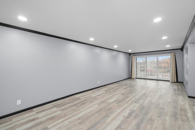 empty room with recessed lighting, baseboards, crown molding, and light wood finished floors