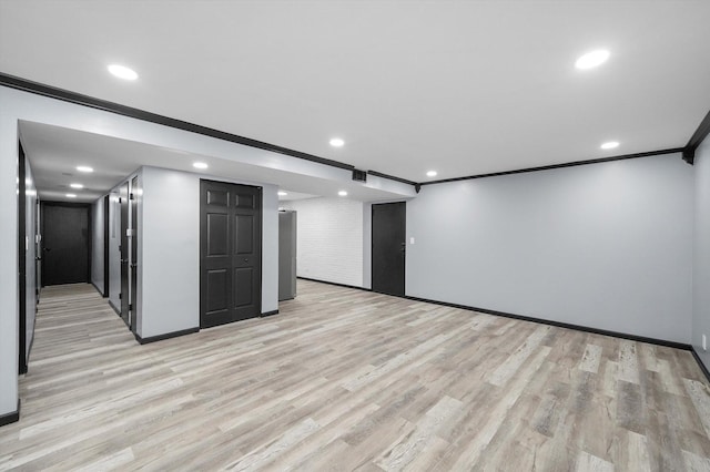 spare room featuring recessed lighting, crown molding, light wood-style flooring, and baseboards