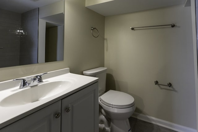 bathroom with baseboards, vanity, and toilet