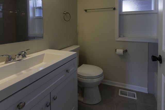 bathroom featuring visible vents, toilet, vanity, baseboards, and tile patterned floors