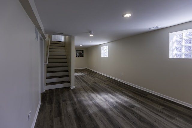 below grade area with stairway, baseboards, visible vents, and dark wood-style flooring