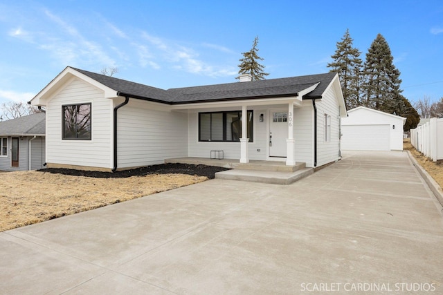 view of front of home with a detached garage, roof with shingles, fence, an outdoor structure, and a porch