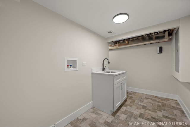 laundry room featuring hookup for a washing machine, a sink, visible vents, baseboards, and cabinet space