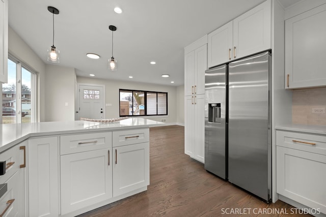 kitchen with light countertops, dark wood-type flooring, white cabinetry, and stainless steel fridge with ice dispenser