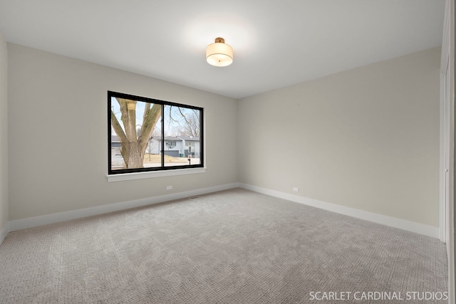 empty room featuring baseboards and carpet flooring