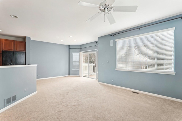 unfurnished living room with light colored carpet, visible vents, baseboards, and recessed lighting