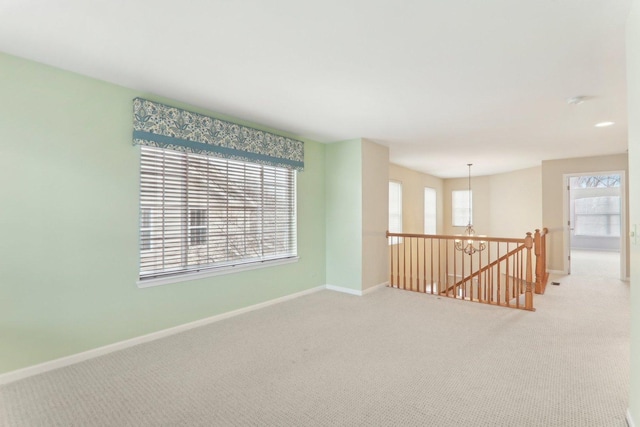 empty room featuring light carpet and baseboards