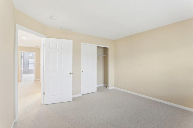 unfurnished bedroom featuring light carpet and baseboards