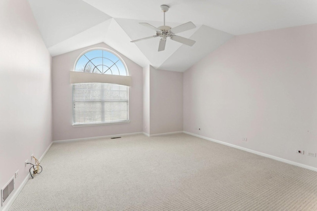 spare room featuring carpet, lofted ceiling, visible vents, a ceiling fan, and baseboards