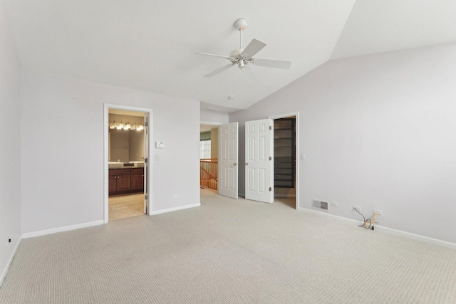 unfurnished bedroom with lofted ceiling, visible vents, light carpet, and baseboards