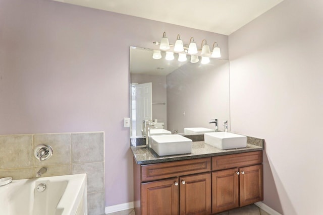 bathroom with a garden tub, double vanity, a sink, and baseboards