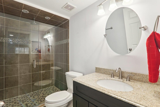 full bath with a stall shower, visible vents, vanity, and toilet