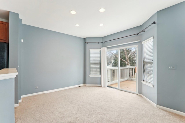 unfurnished room with recessed lighting, light carpet, and baseboards