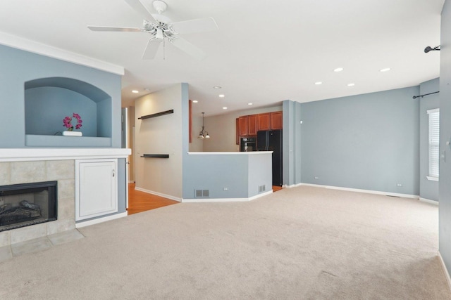 unfurnished living room featuring carpet floors, a tile fireplace, baseboards, and recessed lighting