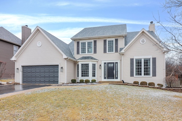 view of front of home featuring aphalt driveway, a front yard, a chimney, and an attached garage