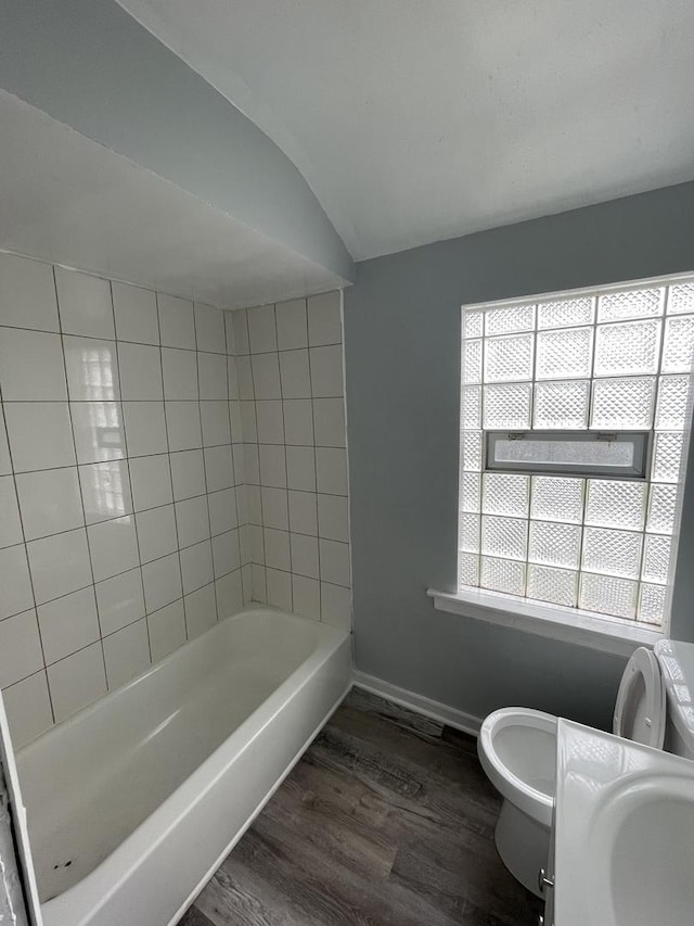 bathroom featuring baseboards, a healthy amount of sunlight, toilet, and wood finished floors