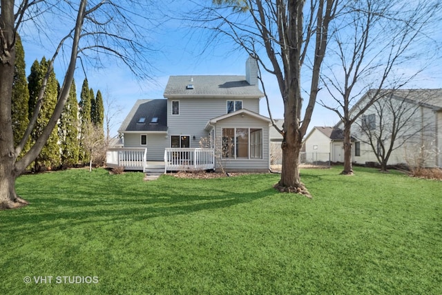 rear view of property with a yard, fence, a chimney, and a wooden deck