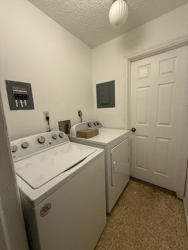 laundry area featuring laundry area, electric panel, a textured ceiling, and separate washer and dryer