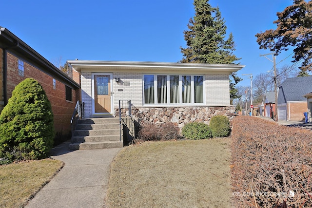 view of front facade featuring brick siding and stone siding