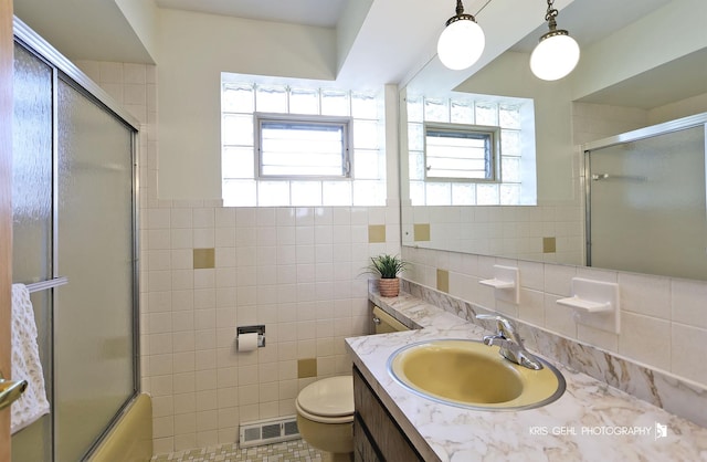 bathroom featuring visible vents, toilet, tile walls, and vanity