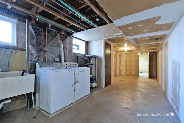 below grade area featuring a sink, visible vents, and separate washer and dryer