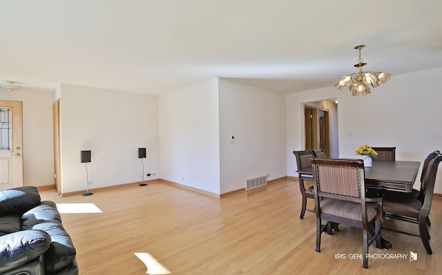 dining room featuring a notable chandelier, baseboards, visible vents, and light wood finished floors