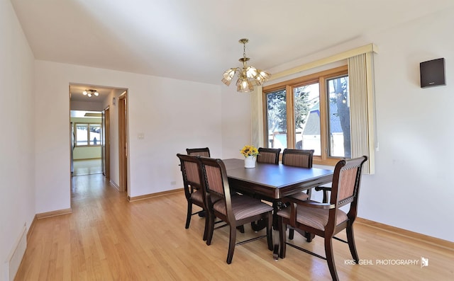 dining area featuring visible vents, baseboards, light wood-style floors, and a notable chandelier