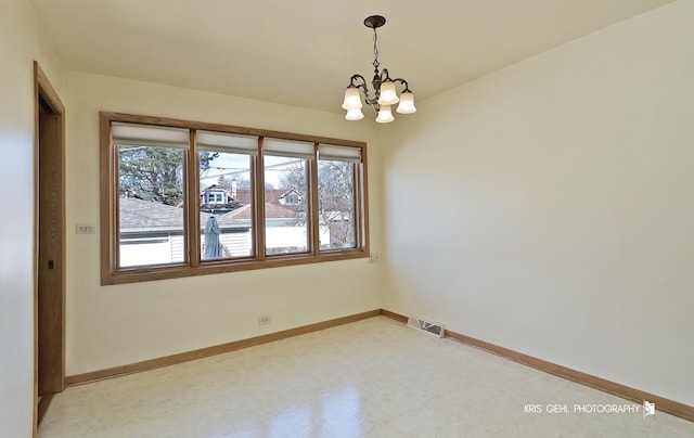 unfurnished room with visible vents, baseboards, and an inviting chandelier