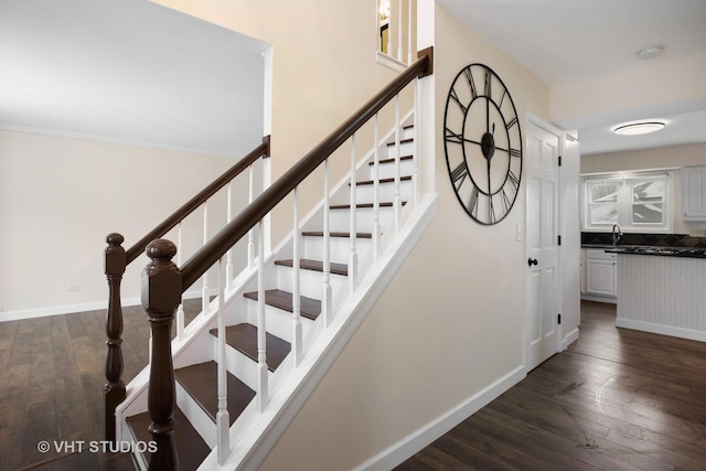 staircase featuring baseboards and hardwood / wood-style flooring