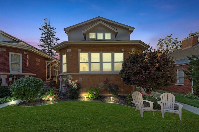 view of front facade with a front yard and brick siding