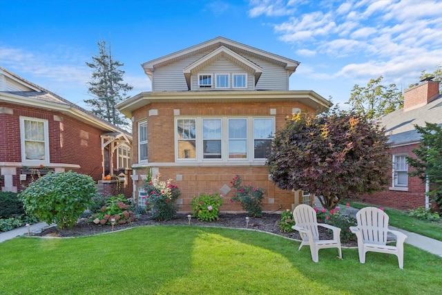 view of front facade with brick siding and a front yard