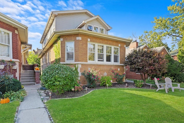 view of front of home with brick siding and a front lawn