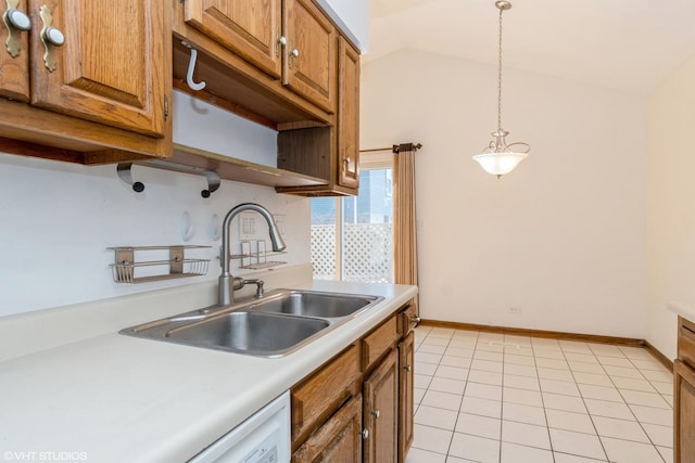 kitchen with lofted ceiling, light tile patterned floors, a sink, light countertops, and brown cabinets