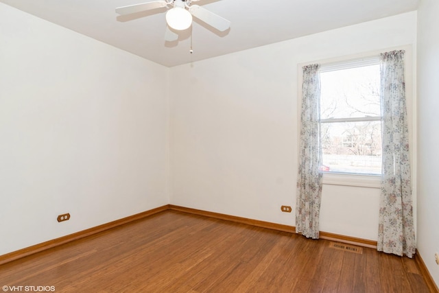 unfurnished room with visible vents, baseboards, ceiling fan, and wood finished floors