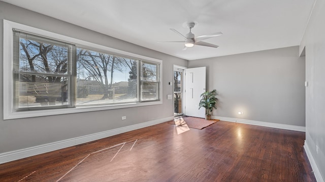 unfurnished room with a ceiling fan, wood finished floors, and baseboards