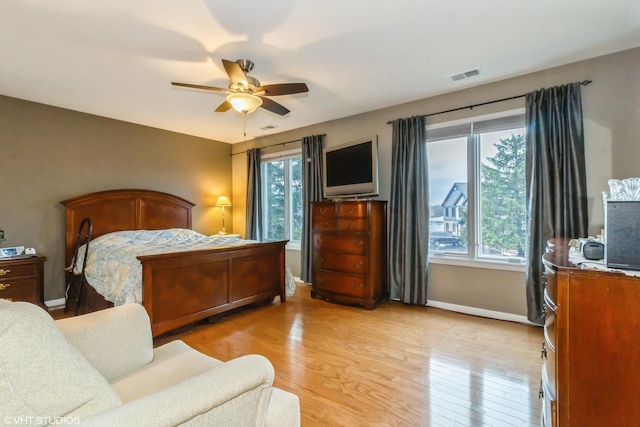 bedroom with light wood finished floors, multiple windows, and visible vents