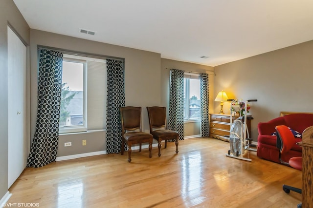 sitting room featuring light wood finished floors, visible vents, and baseboards